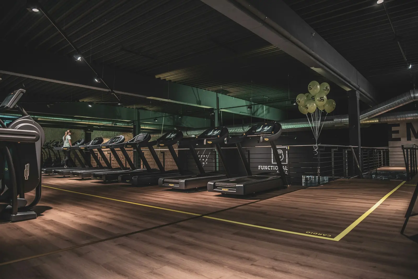 Interior de uma academia com piso de treino e equipamentos